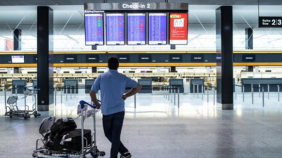 A passenger is looking at the departures board at the Zurich Airport in Zuerich, Switzerland, Tuesday, March 10, 2020. The spreading of the Coronavirus has effects on the passenger volume at Switzerla ...