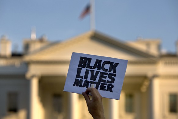 FILE - In this July 8, 2016 file photo, a man holds up a sign saying &quot;black lives matter&quot; during a protest of shootings by police, at the White House in Washington. Black social media users  ...