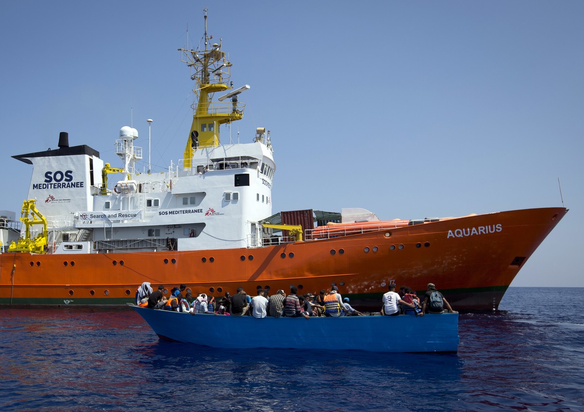 FILE - In this Aug. 29, 2017 file photo, African migrants float on a wooden boat next to a rescue ship during a search and rescue operation conducted by SOS Mediterranee's Aquarius ship and MSF ( ...
