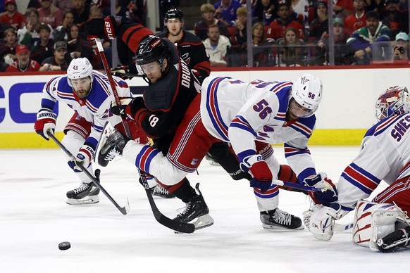Carolina Hurricanes&#039; Jack Drury (18) chases the puck between New York Rangers&#039; Erik Gustafsson (56) and Barclay Goodrow (21) during the second period in Game 4 of an NHL hockey Stanley Cup s ...
