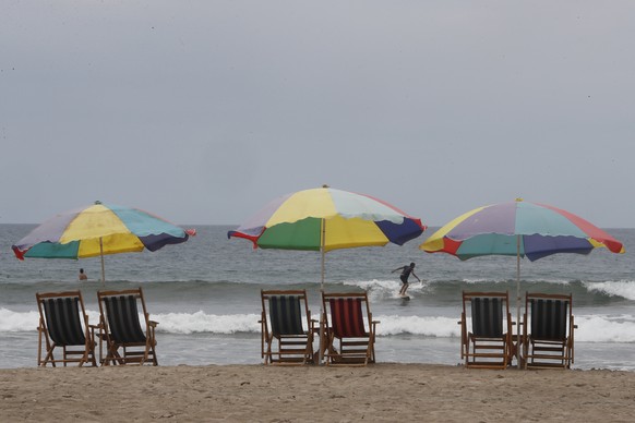 epa11883772 A man surfs at a beach in Olon, Ecuador, 08 February 2025. Ecuador's President, Daniel Noboa, who won the extraordinary elections of 2023, seeks reelection for a full term (2025-2029) ...