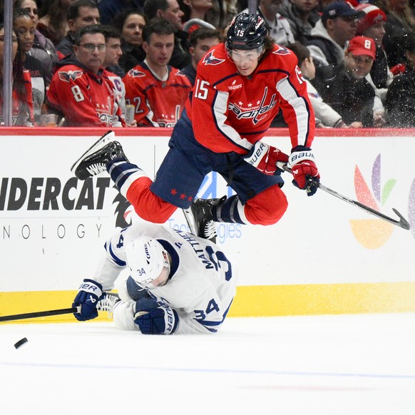 Washington Capitals left wing Sonny Milano (15) jumps past Toronto Maple Leafs center Auston Matthews during the second period of an NHL hockey game, Thursday, Dec. 18, 2025, in Washington. (AP Photo/ ...