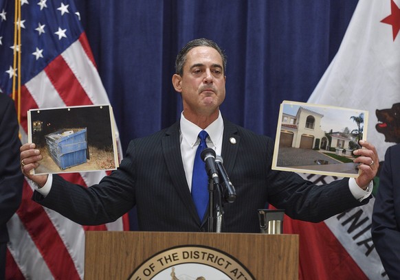 Orange County District Attorney Todd Spitzer holds up pictures of the home of Peter Chadwick and the dumpster where his wife&#039;s body was found during a news conference in Santa Ana, Calif., on Tue ...