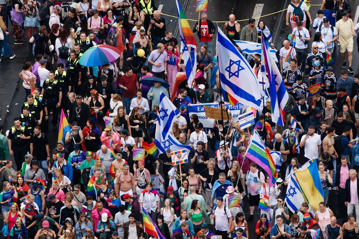 epa11499072 Police officers accompany participants with Israel flags during the 'CSD Berlin 2024' the 46th Christopher Street Day parade in Berlin, Germany, 27 July 2024. CSD is an annual Eu ...