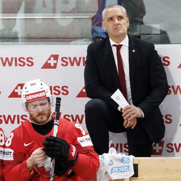 From left, Switzerland's Sven Andrighetto, Switzerland's Christoph Bertschy and Jan Cadieux, head coach of Switzerland during the 2026 IIHF Men's Ice Hockey World Championship gold meda ...