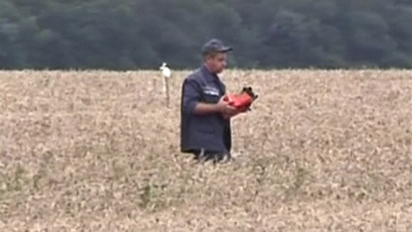 Ein ukrainischer Katastrophenschutzmitarbeiter findet am Freitag nach dem Abschuss der MH17 einen der beiden Flugschreiber (18.07.2014).