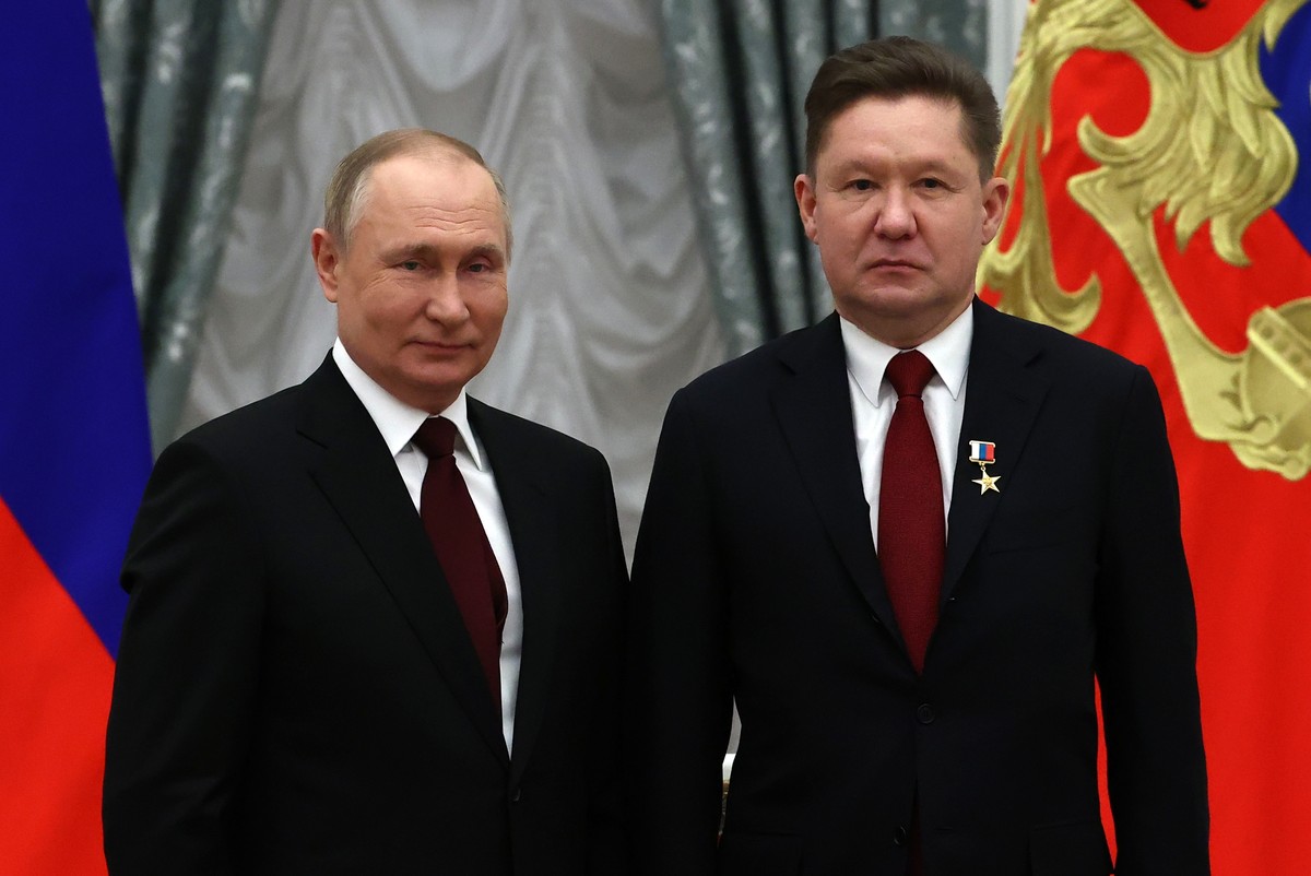 epa09723113 Russian President Vladimir Putin (L) and Chairman of Gazprom Management Committee Alexei Miller (R), who was awarded the Hero of Labor of the Russian Federation title, pose for a photograp ...