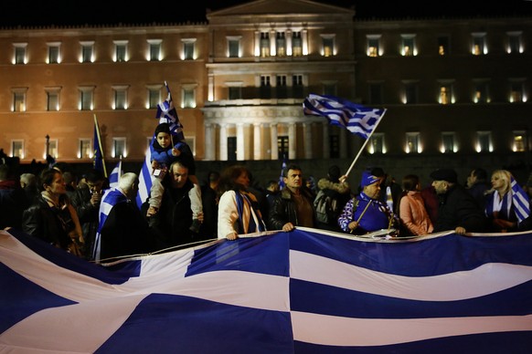 epa07316502 Protesters hold the Greece national flags during a demonstration against the Prespes Agreement between Athens and Skopje regarding the name &#039;Northern Macedonia&#039; for the Balkan co ...