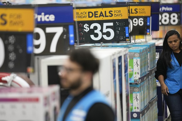 Signs advertise deals and low prices at a Walmart in Secaucus, N.J., Tuesday, Nov. 22, 2022. After last year's holiday season of skimpy discounts, American are seeing price cuts across the board for t ...