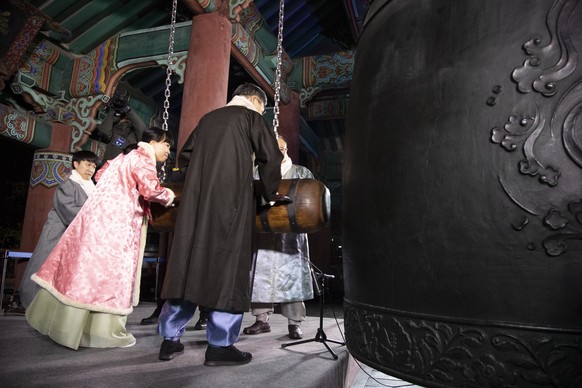 epa10384057 South Korean people strike a big bell during New Year celebrations in Seoul, South Korea, 01 January 2023. EPA/JEON HEON-KYUN/POOL