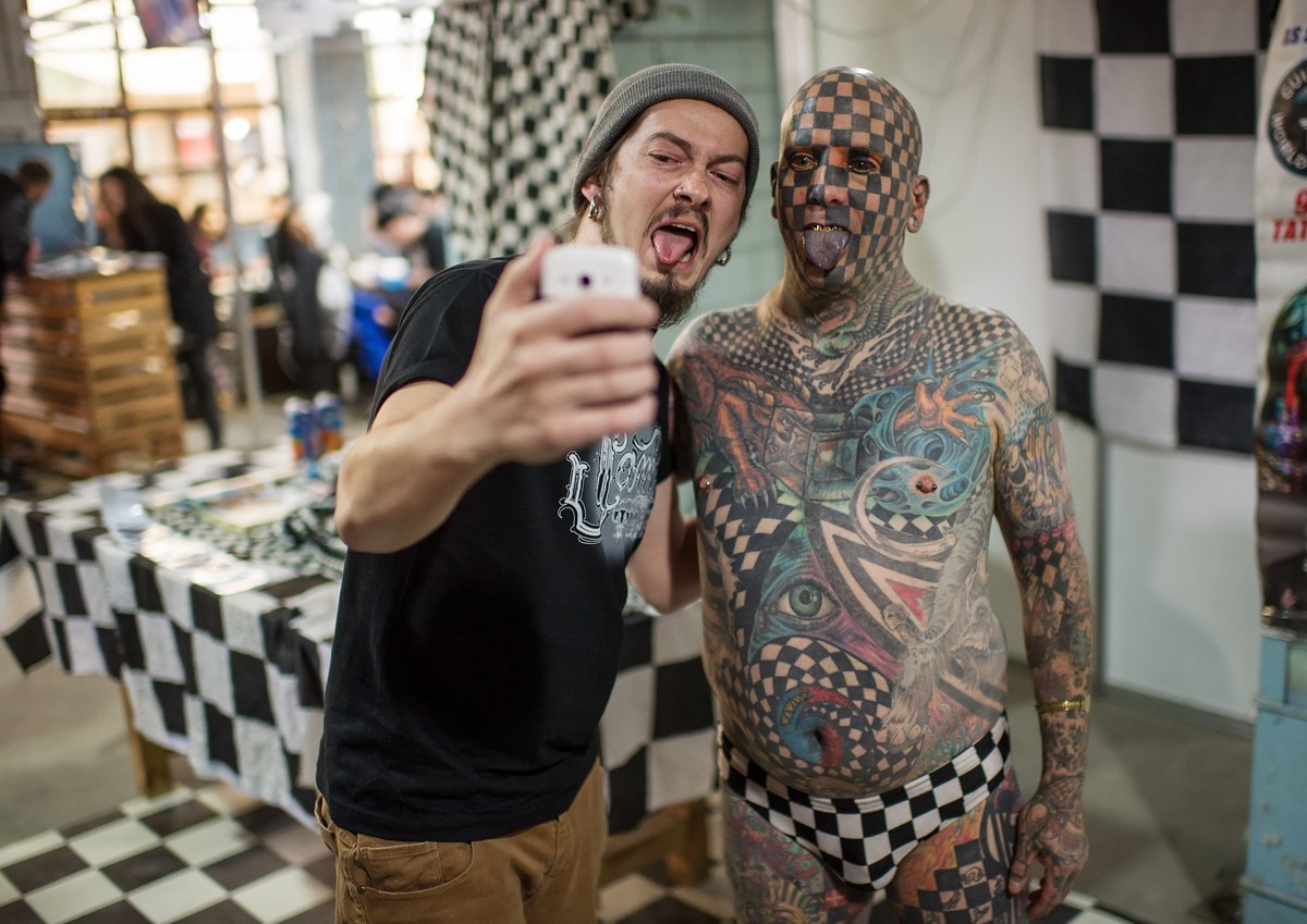epa05319905 US tattoo star Matt Gone (R) poses for a selfie with a visitor during the Tattoo Collection Festival in Kiev, Ukraine, 20 May 2016. Matt Gone, often referred as 'Human Chequerboard  ...