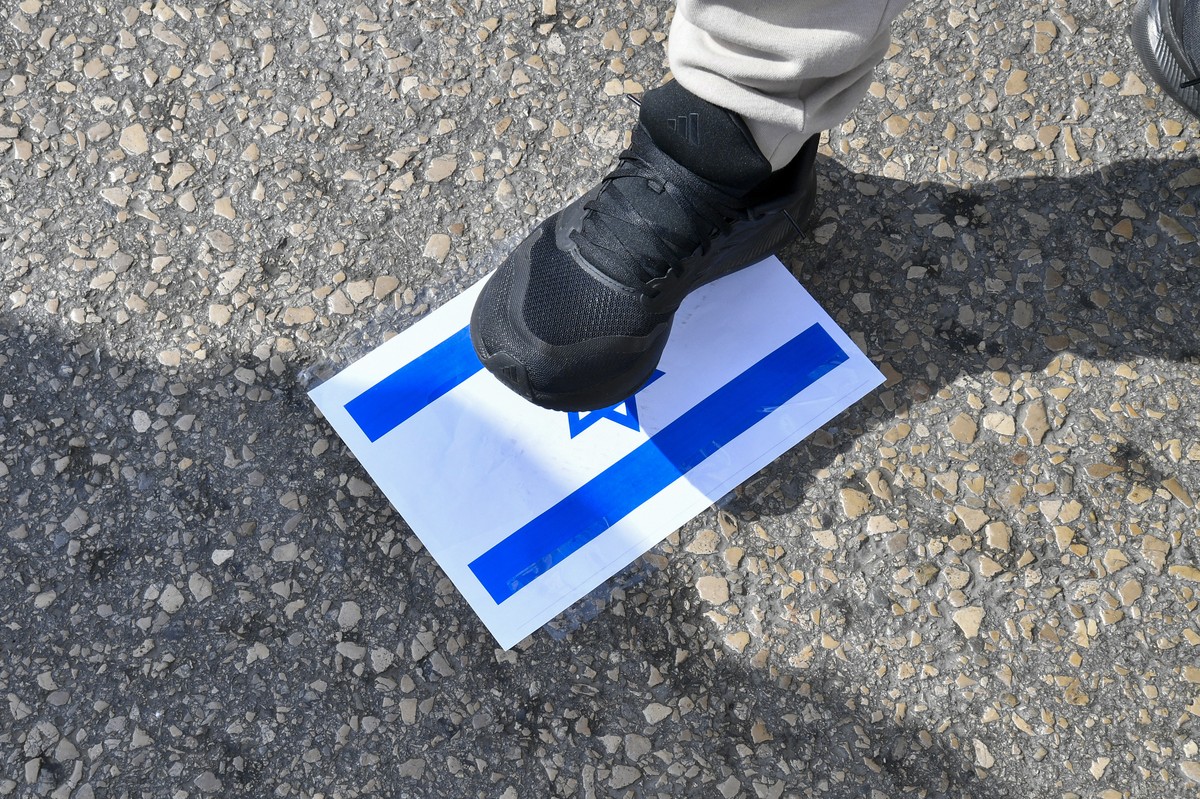 epa12883043 A Hezbollah supporter steps on an Israeli flag during a protest against Lebanese President and Prime Minister outside the Government Palace in downtown Beirut, Lebanon, 11 April 2026. The  ...