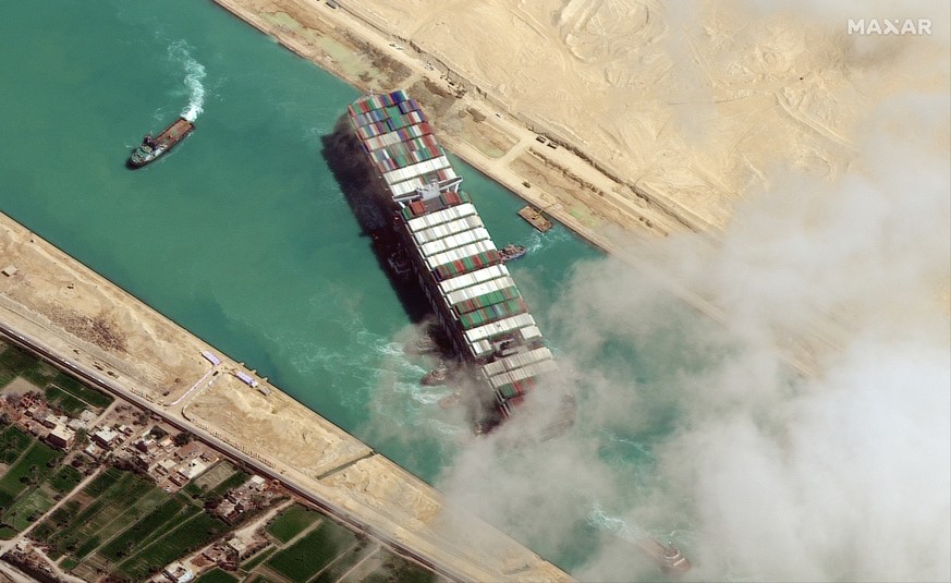 epa09105221 A handout satellite image made available by MAXAR Technologies shows , the Ever Given container ship after it has been moved away from the eastern bank of the canal and tugboats trying to  ...