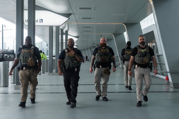 epa12854954 Immigration and Customs Enforcement (ICE) officers walk outside Terminal B of LaGuardia International Airport in New York, New York, USA, 27 March 2026. ICE officers were deployed at major ...