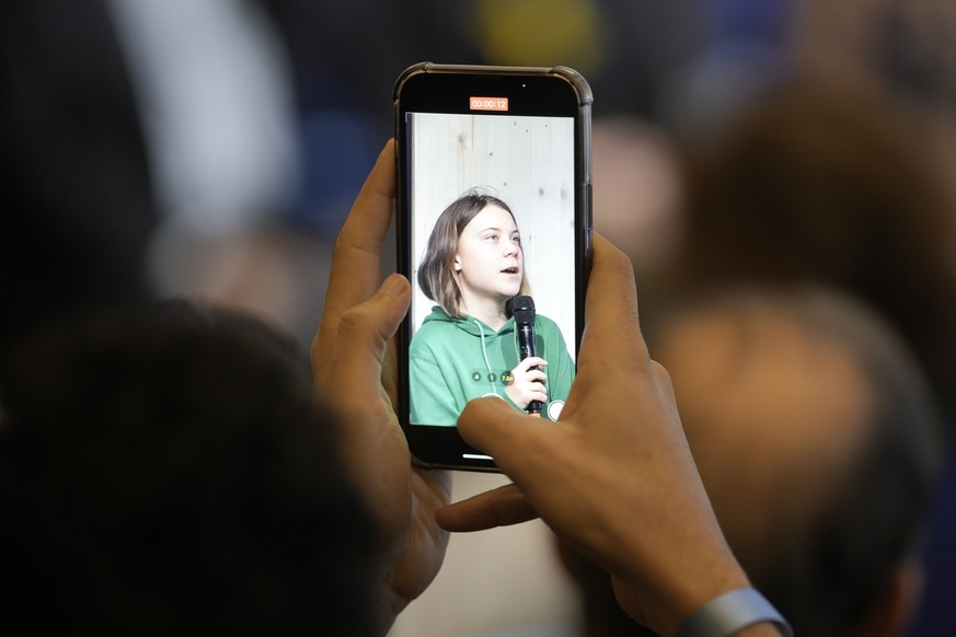 Climate activists Greta Thunberg of Sweden is pictured with a mobile phone at a press conference at the World Economic Forum in Davos, Switzerland Thursday, Jan. 19, 2023. The annual meeting of the Wo ...