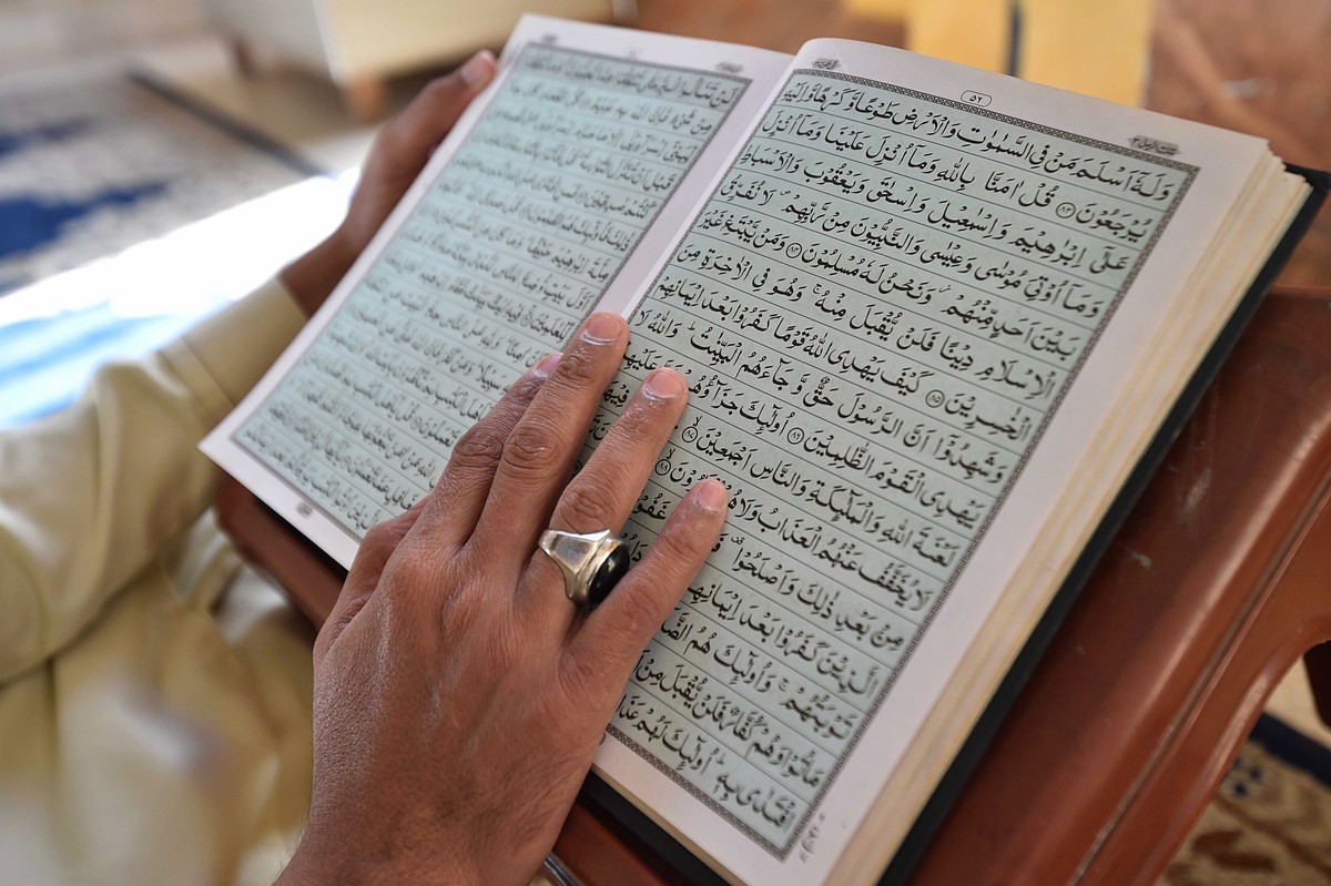 epa11939724 A Pakistani Muslim man reads from a copy of the Muslims' holy book, the Quran, at a mosque during the fasting month of Ramadan, in Karachi, Pakistan, 04 March 2025. Muslims around the ...