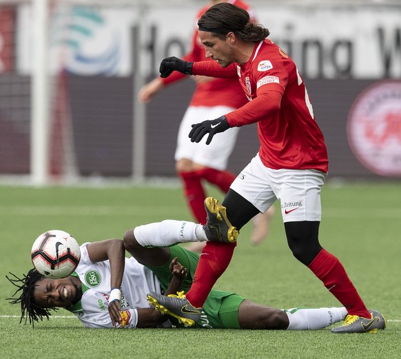 Thuns Kevin Bigler, rechts, im Duell mit St. Gallens Majeed Ashimeru im Fussball Meisterschaftsspiel der Super League zwischen dem FC Thun und dem FC St. Gallen, am Sonntag, 14. April 2019, in der Sto ...