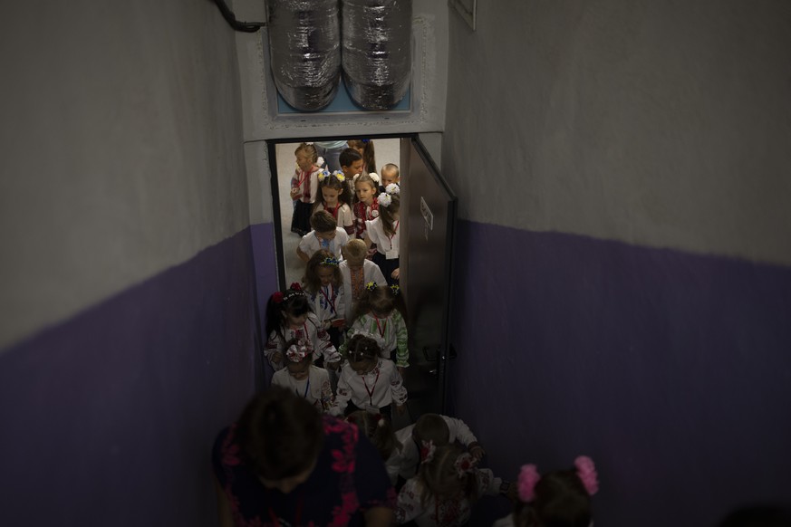 Students leave a shelter after an evacuation training during their first day of school at a public school in Irpin, Ukraine, Thursday, Sept. 1, 2022. Ukrainian children return to school without sharin ...