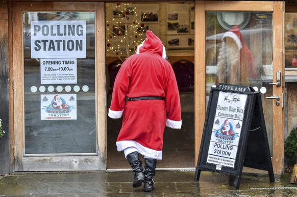 A man dressed as Father Christmas enters his grotto at the Dunster Tithe Barn near Minehead, Somerset, England which is being used as a polling station in the 2019 general election, Thursday Dec. 12,  ...