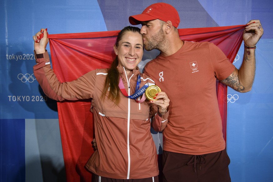 Gold medal winner Belinda Bencic, left, of Switzerland poses with her medal, a Swiss flag and her coach Martin Hromkovic, right, after winning the games against Marketa Vondrousova of Czech Republic d ...