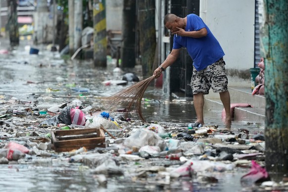 A man cleans garbage along a flooded street due to Typhoon Fung-wong and high tide on Monday, Nov. 10, 2025, in Navotas, Philippines. (AP Photo/Aaron Favila)
Philippines Extreme Weather Asia Typhoon