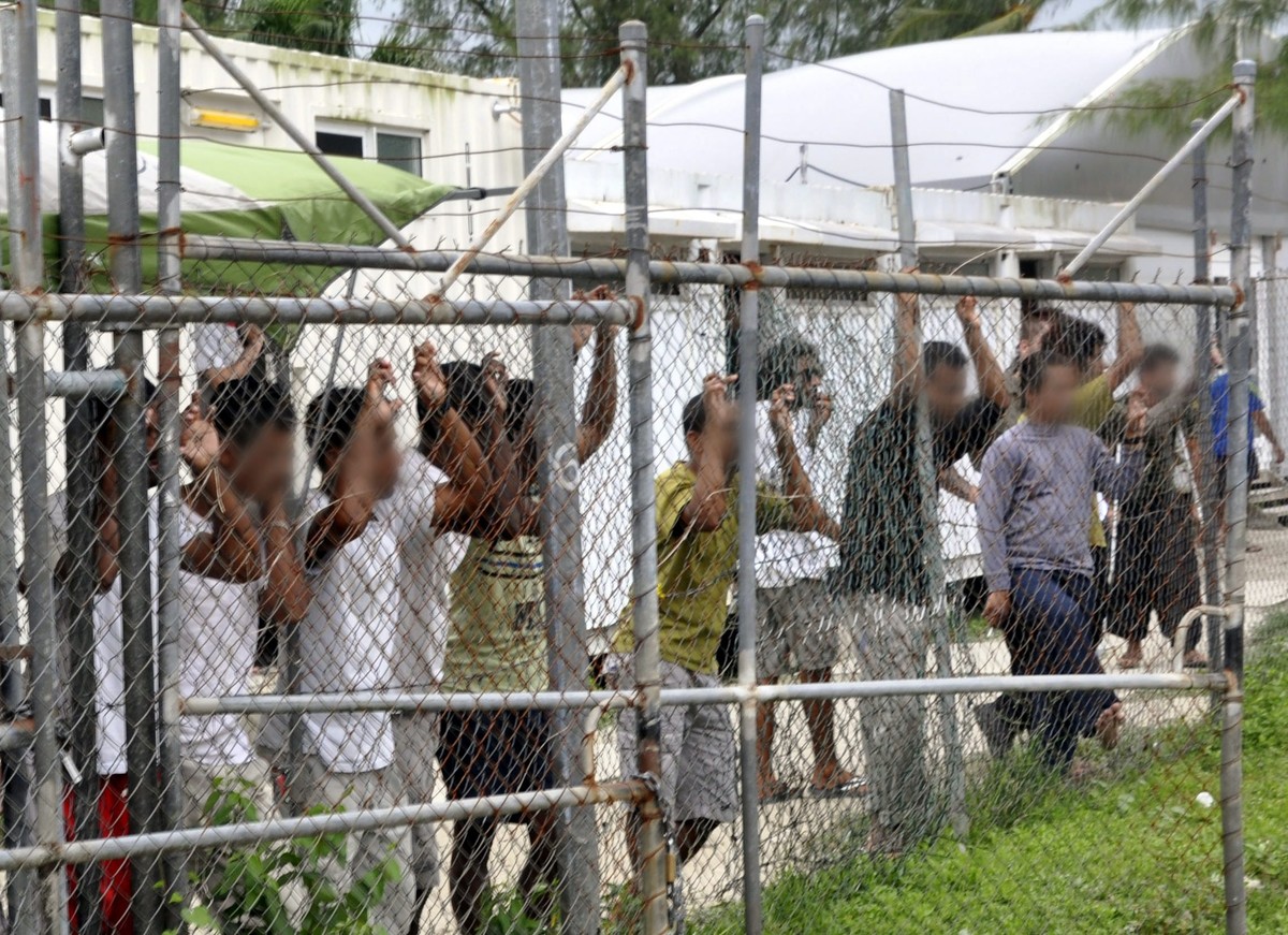 epa05492312 (FILE) A file picture dated dated 21 March 2014 shows asylum seekers behind a fence at the Manus Island detention center, in Papua New Guinea. Australia and paua New Guinea agreed to close ...