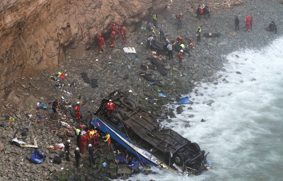 epa06413910 A group of emergency personnel works to rescue victims after a passenger bus plunged off the Pan-American Highway North, about 45 kilometers from Lima, Peru, 02 January 2018. At least 36 p ...