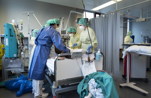 Aerzte und Pflegende kuemmern sich um Covid-Patienten auf der Covid-19-Intensivabteilung im Stadtspital Triemli am 10. Dezember 2020 in Zuerich. (KEYSTONE/Gaetan Bally)