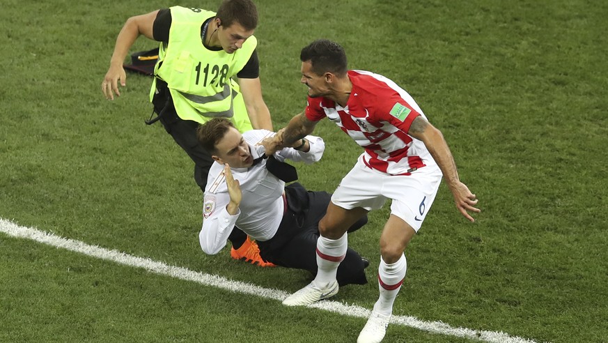 Croatia&#039;s Dejan Lovren and a steward grab a man who invaded the pitch during the final match between France and Croatia at the 2018 soccer World Cup in the Luzhniki Stadium in Moscow, Russia, Sun ...