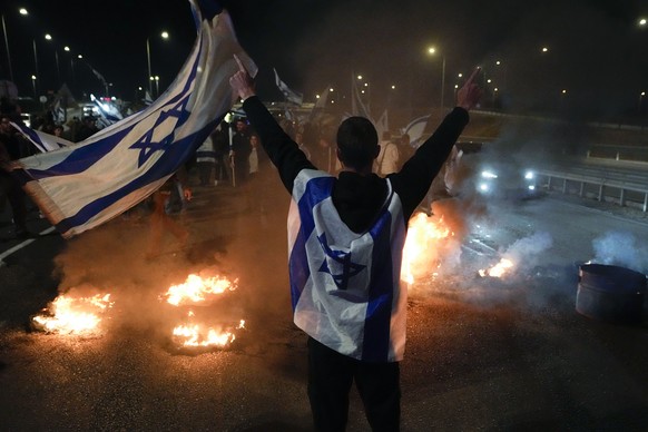 Anti-government protestors burn tires near Beit Yanai, Israel, Monday, March 27, 2023. Tens of thousands Israelis protest against Prime Minister Benjamin Netanyahu&#039;s judicial overhaul plan.(AP Ph ...
