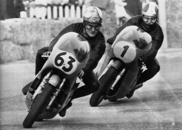 World champion Giacomo Agostini of Italy closely follows British ace Mike Hailwood at the beginning of the 500cc class event of the Riccione International Motorcycling Circuit, March 30, 1969 at the f ...