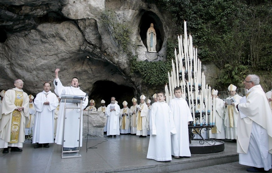 epa01252135 Bishops pray to the Statue of Our Lady of Lourdes during the 150 th anniversary of the manifestation of the Virgin Mary at the Grotto of Massabielle, with his Eminence Jacques Perrier (L), ...
