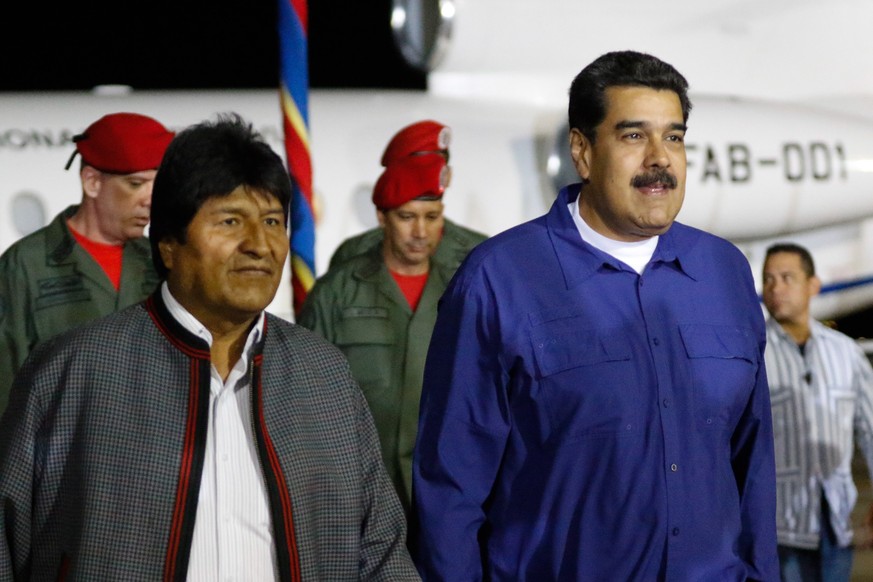 epa07337583 A handout photo made available by Miraflores Press shows the President of Venezuela Nicolas Maduro (R) walking with President of Bolivia Evo Morales (L) prior to their meeting in Maiquetia ...