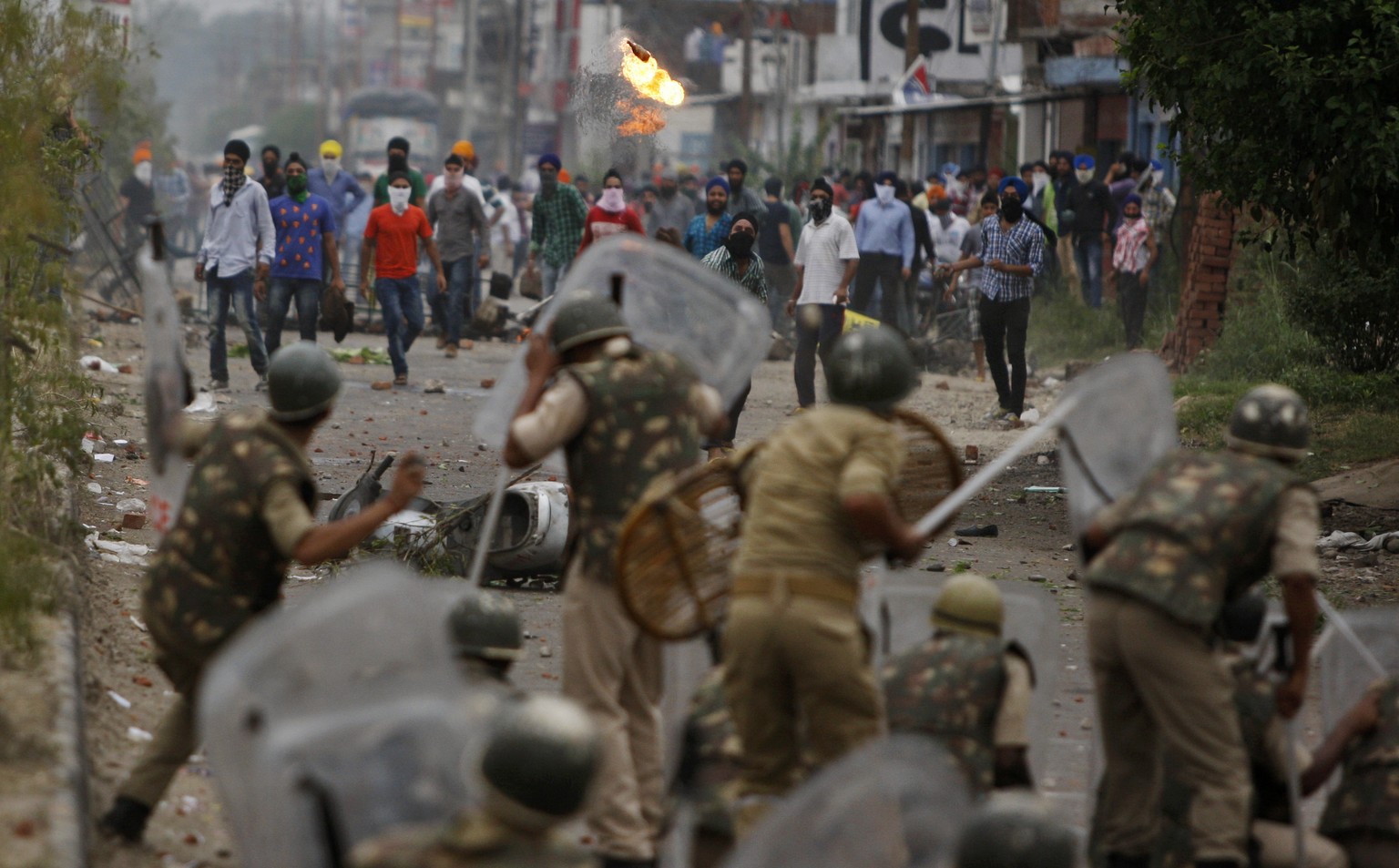 A Sikh protester throws a petrol bomb at Indian police during a protest in Jammu, India, Thursday, June 4, 2015. The protests triggered by the removal of posters of Sikh leader Jarnail Singh Bhindranw ...