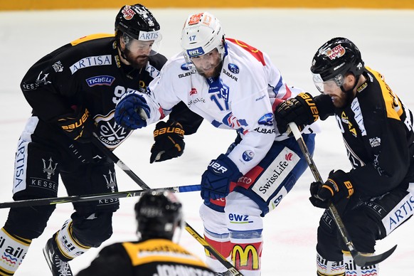 LuganoÃs player Thomas Wellinger, Zurich&#039;s player Drew Shore and LuganoÃs player Matteo Romanenghi, from left, during the fifth match of the playoff final of the National League of the ice hock ...