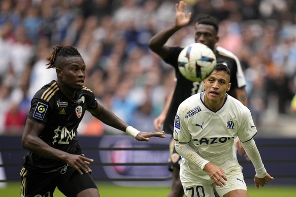 Ajaccio&#039;s Youssouf Kone, left, follows the ball with Marseille&#039;s Alexis Sanchez during the French League One soccer match between Marseille and Ajaccio at the Velodrome stadium in Marseille, ...