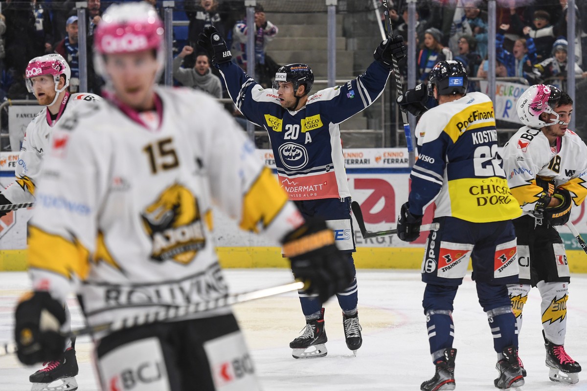 Ambri's player Elias Bianchi, center, celebrates the 2-1 goal against Ajoie's goalkeeper Tim Wolf, during the match of National League A (NLA) Swiss Championship 2021/22 between HC Ambri Pio ...