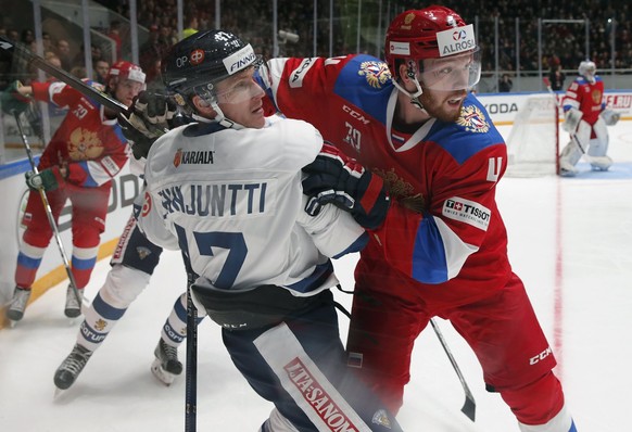 epa05781002 Antti Erkinjuntti (C) of Finland in action against Vladislav Gavrikov (R) of Russia during the Euro Hockey Tour match between Russia and Finland at the Yubileiny Palace in St. Petersburg,  ...