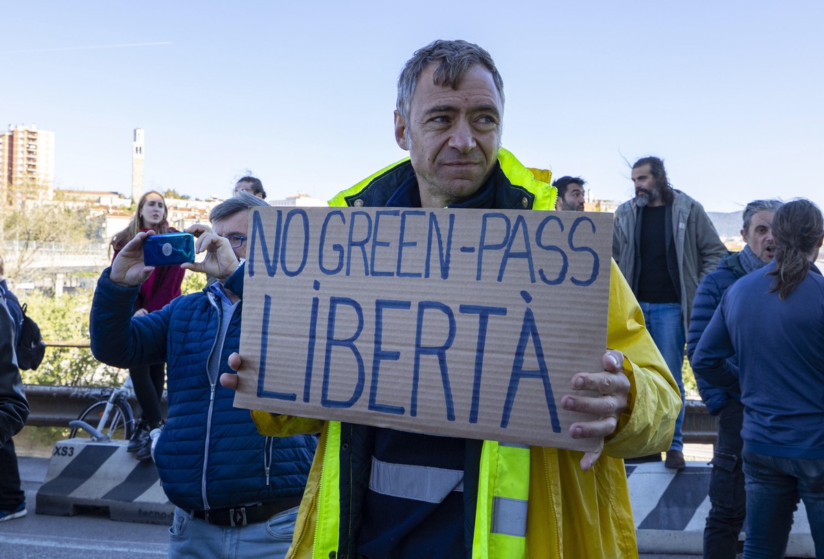epaselect epa09525245 A demonstrator holds a placard reading 'No Green Pass - Freedom' during a protest against the Green Pass in the port of Trieste, northern Italy, 15 October 2021, as the ...