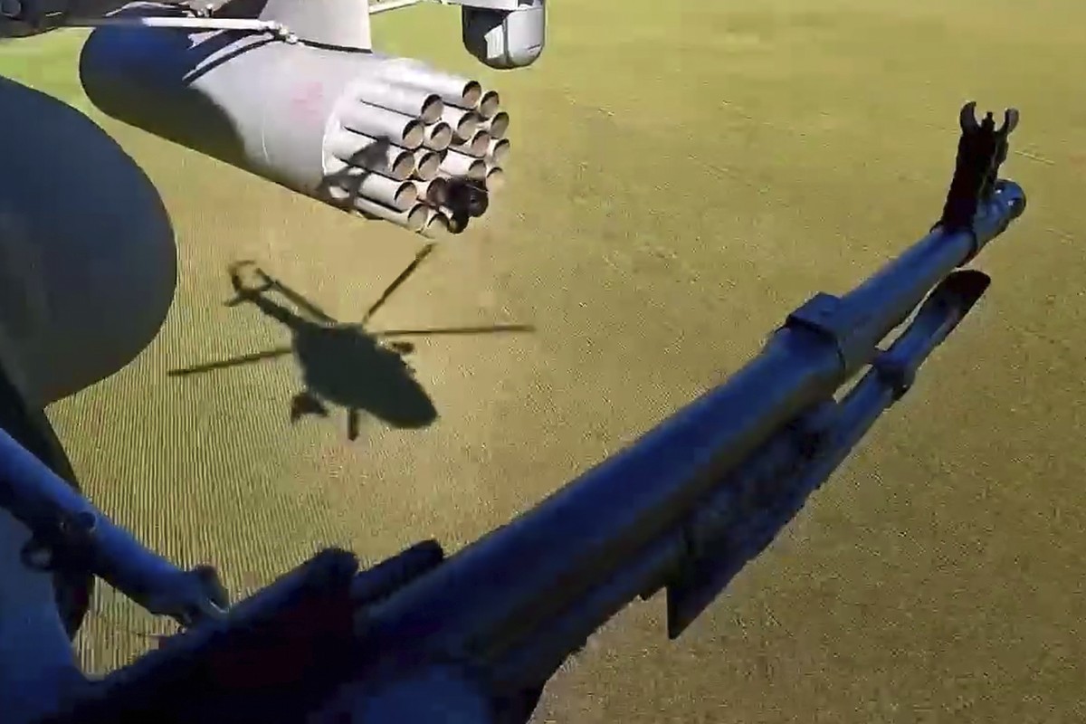 In this photo taken from video distributed by Russian Defense Ministry Press Service on Monday, May 19, 2025, A Russian Army soldier controls an area from a board of military helicopter in an undisclo ...