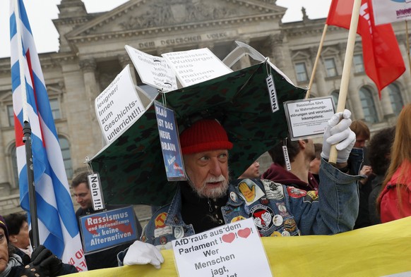 epa06285519 A protester against the German populist right-wing &#039;Alternative for Germany&#039;(AfD) party jons a rally in front of the German &#039;Bundestag&#039; parliament, in Berlin, Germany,  ...