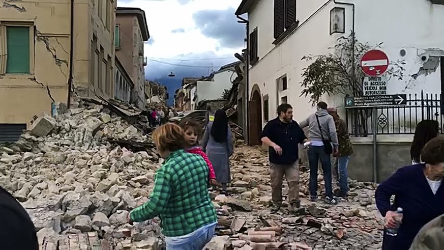 This still image taken from video shows survivors and rescuers wandering in the center of Amatrice, central Italy, where a 6.1 earthquake struck just after 3:30 a.m., Wednesday, Aug. 24, 2016. The qua ...