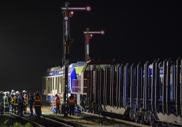 Emergency services attend the scene after a cargo train and a passenger train collided in Aichach, 50 Kilometers west of Munich, southern Germany, Monday, May 7, 2018. At least two people have been ki ...