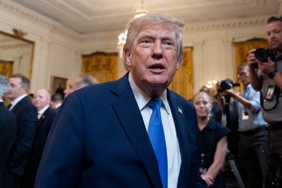 President Donald Trump speaks with a reporter as he departs after an event for Olympic athletes, coaches, staff, and representatives from Team USA in the East Room of the White House, Thursday, Aug. 6 ...