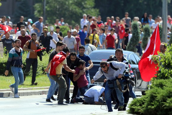 Supporters of Turkey's President Recep Tayyip Erdogan, who were staging a protest against a coup, clash with Turkish journalists near the Turkish military headquarters, in Ankara, Turkey, Saturday, Ju ...