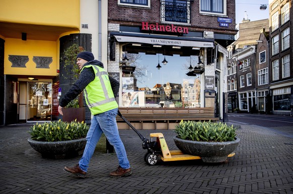 epa08333658 A supplier places tulips at the Nieuwmarkt in the centre of the city for the Tulip Festival Amsterdam, Netherlands, 31 March 2020. The opening of the annual festival has been canceled due  ...