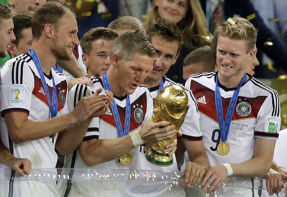 FILE - In this July 13, 2014 file photo Germany&#039;s Bastian Schweinsteiger looks at the trophy after the World Cup final soccer match between Germany and Argentina at the Maracana Stadium in Rio de ...