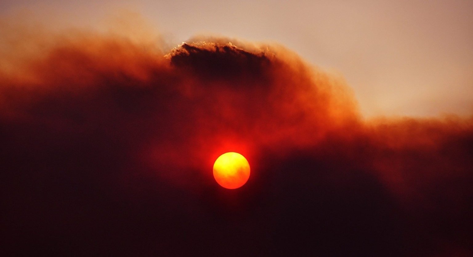 epa03524650 A handout image provided by Kim Foale on 05 January 2013 shows bushfire smoke covering the sun in Tasmania&#039;s Southern Midlands, looking west towards Lake Repulse, Australia, 04 Januar ...