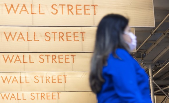 epaselect epa08706384 A person walks past signs for Wall Street near the New York Stock Exchange in New York, New York, USA, 29 September 2020. The Dow Jones industrial average was down in early tradi ...