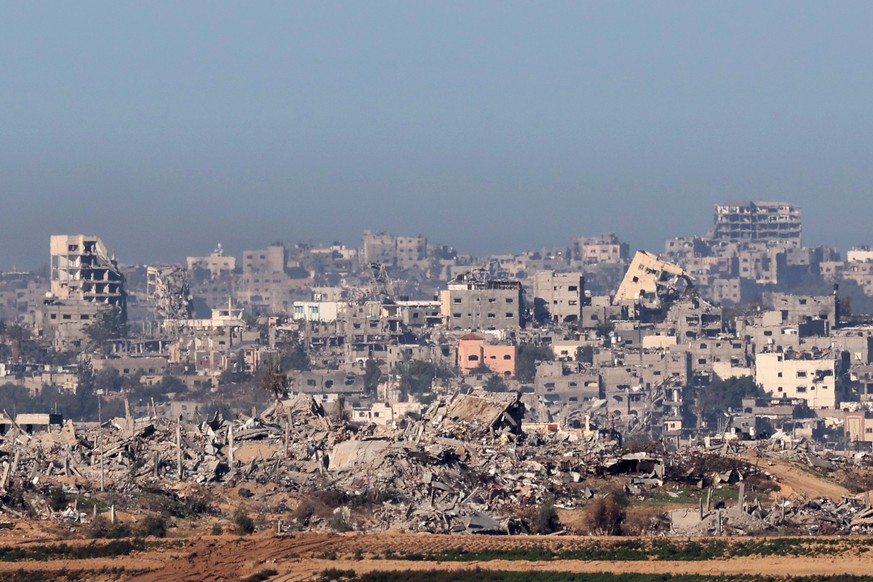 epaselect epa11020744 A view of destroyed buildings after an air strike by Israeli forces in the northern Gaza Strip, as seen from Sderot, Israel, 10 December 2023. Israeli forces resumed military str ...